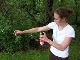 A woman demonstrates deet application.