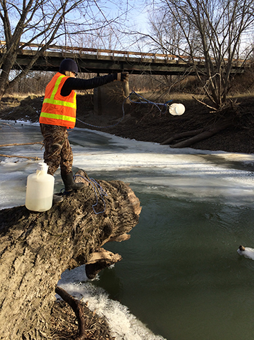 Limnologist Katie
Spoelstra tosses
a collection bottle
tethered by a rope
into the North River
near Norwalk to catch
a water sample that
will be used for water
quality testing.