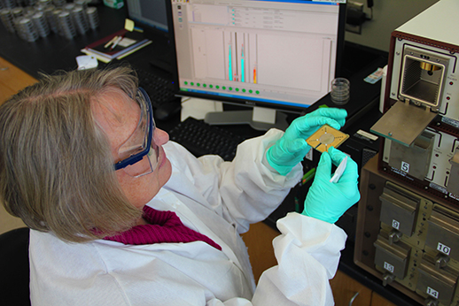 Marinea Mehrhoff, environmental laboratory supervisor, loads a sample for isotopic uranium analysis.