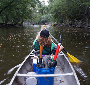 A Project AWARE volunteer canoes a an Iowa waterway.