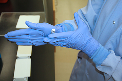 A clinical lab analyst warms a frozen reagent known as a “normal control” before it is used in the Zika testing process.