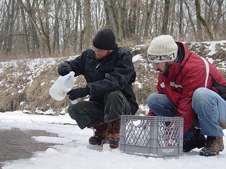 Dennis Heimdal (left) collects a water sample with former SHL limnologist Nathan Ohrt in February 2007.