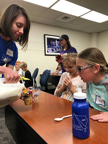 Jenny Puffer (left) of Fox Engineering in Ames helps a fifth-grader build an edible aquifer.